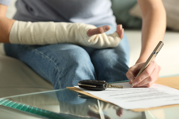 Woman with broken arm signing a document