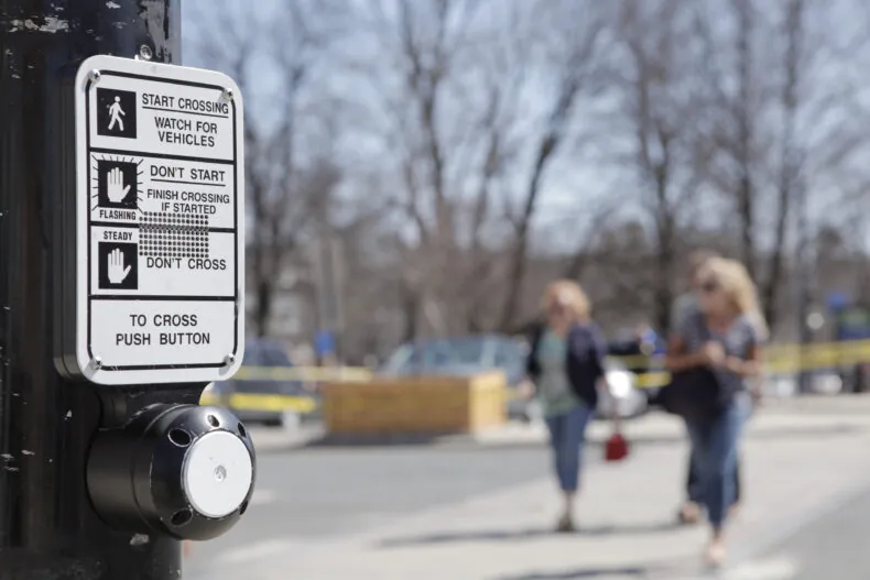 Pedestrians crossing street showing pedestrian button