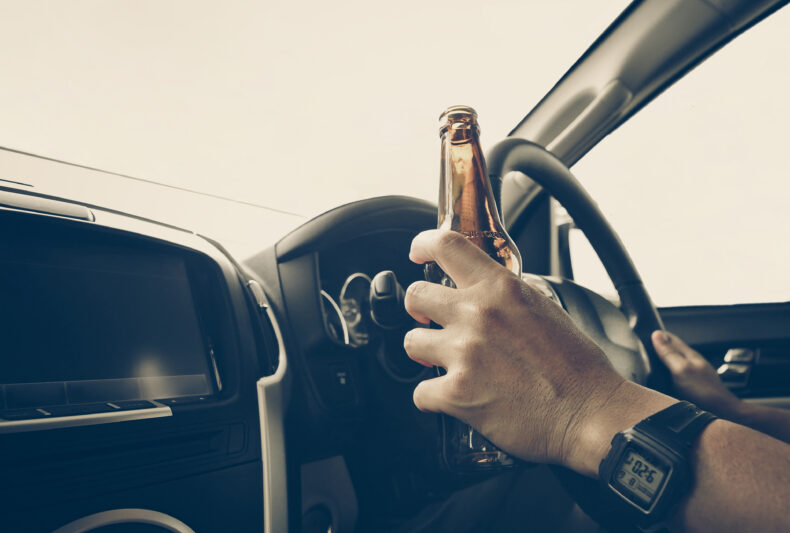 Man holding a beer while driving