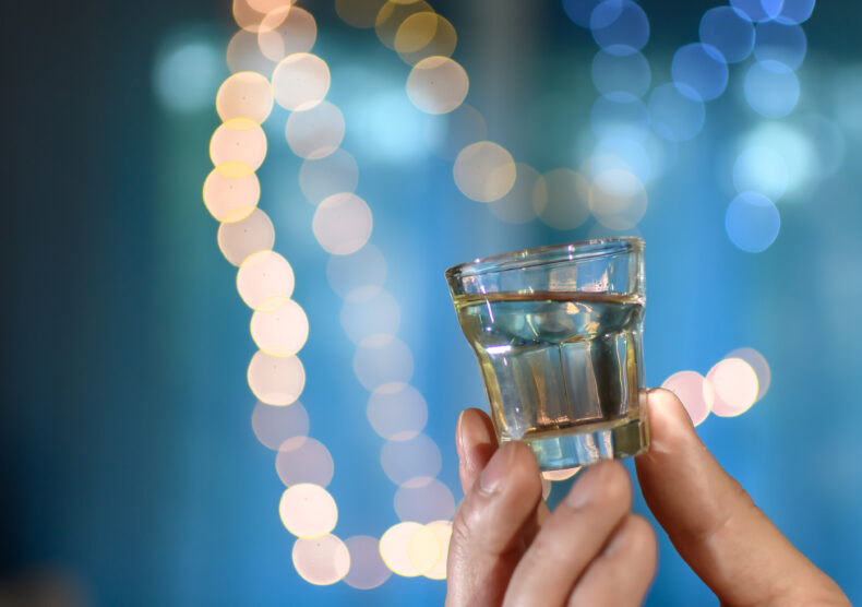 Shot of alcohol with twinkling lights in the background 