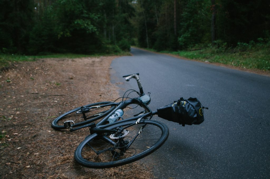 Bicycle laying down on side of rural road