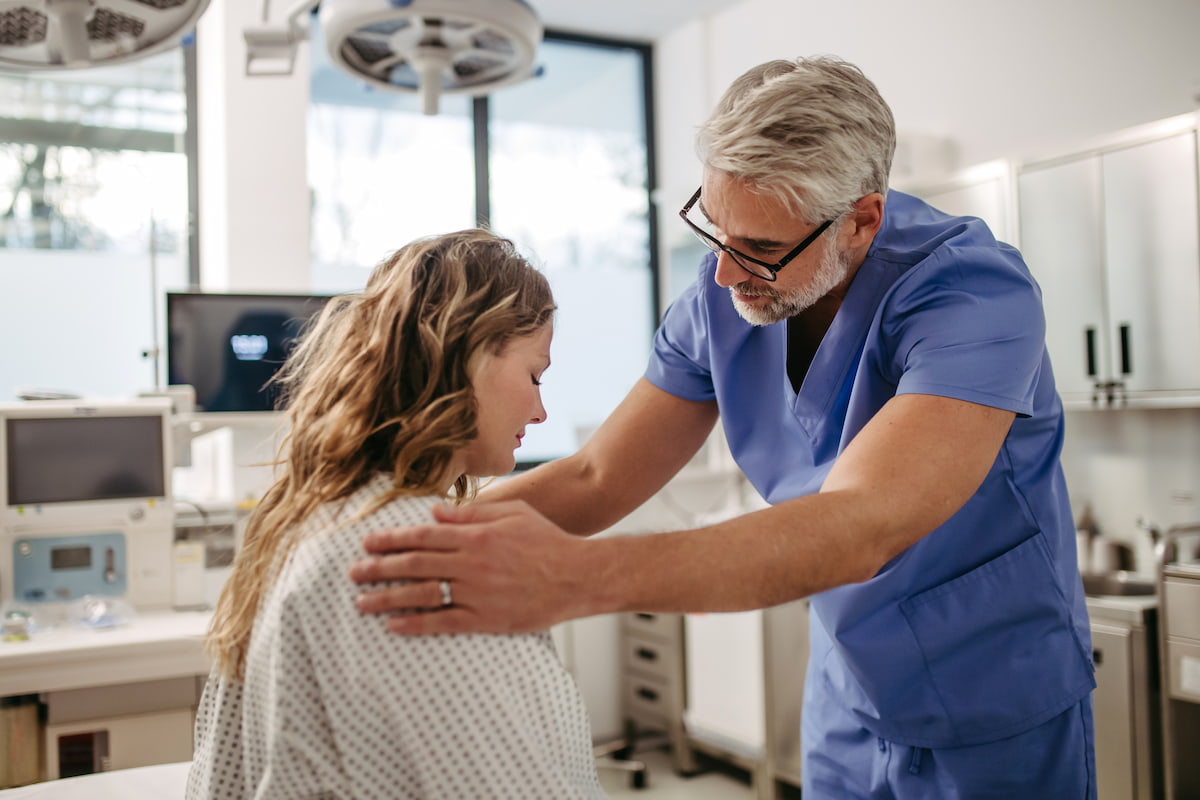 Doctor soothing a distressed patient in hospital.