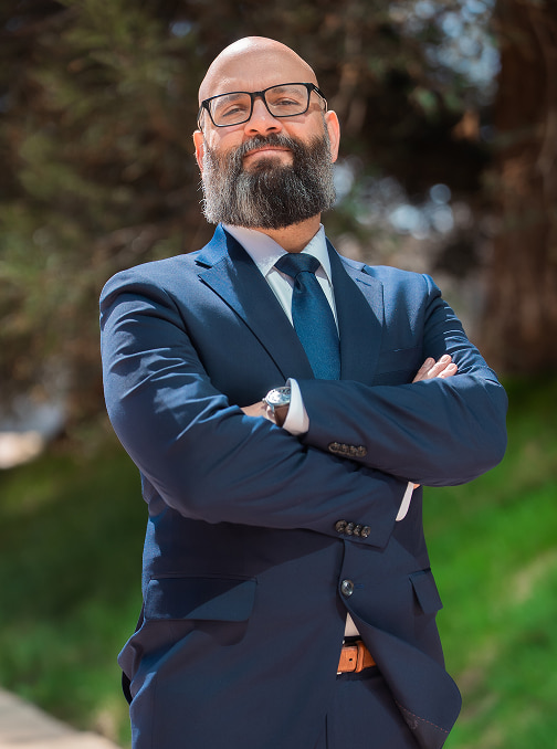 Photo of Issa Mikel outside standing in front of a tree