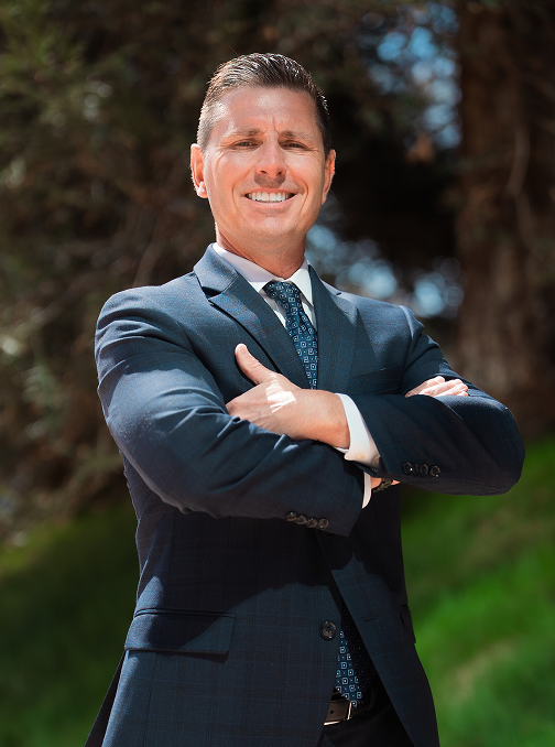 individual in a blue suit standing in an exterior setting