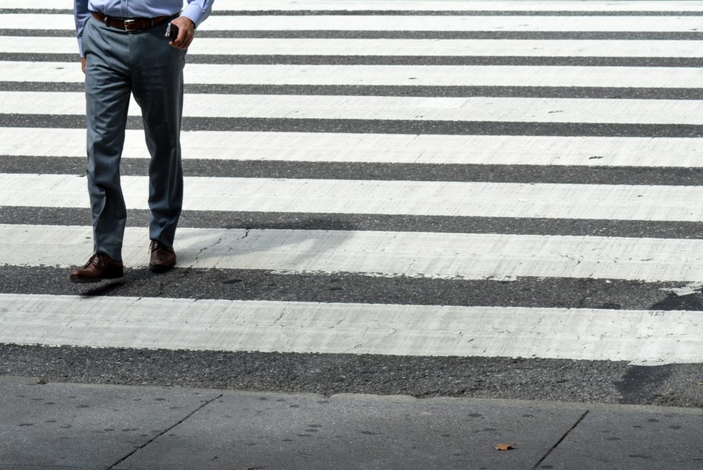 Businessman crossing street at crosswalk