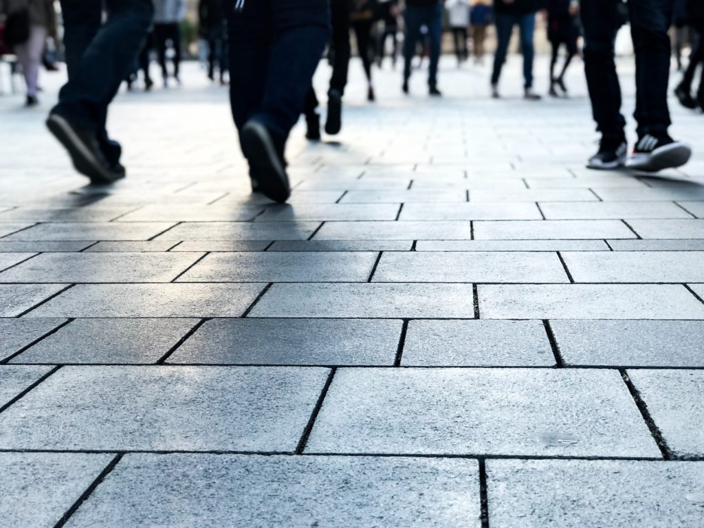 People walking on a stone tile floor outside