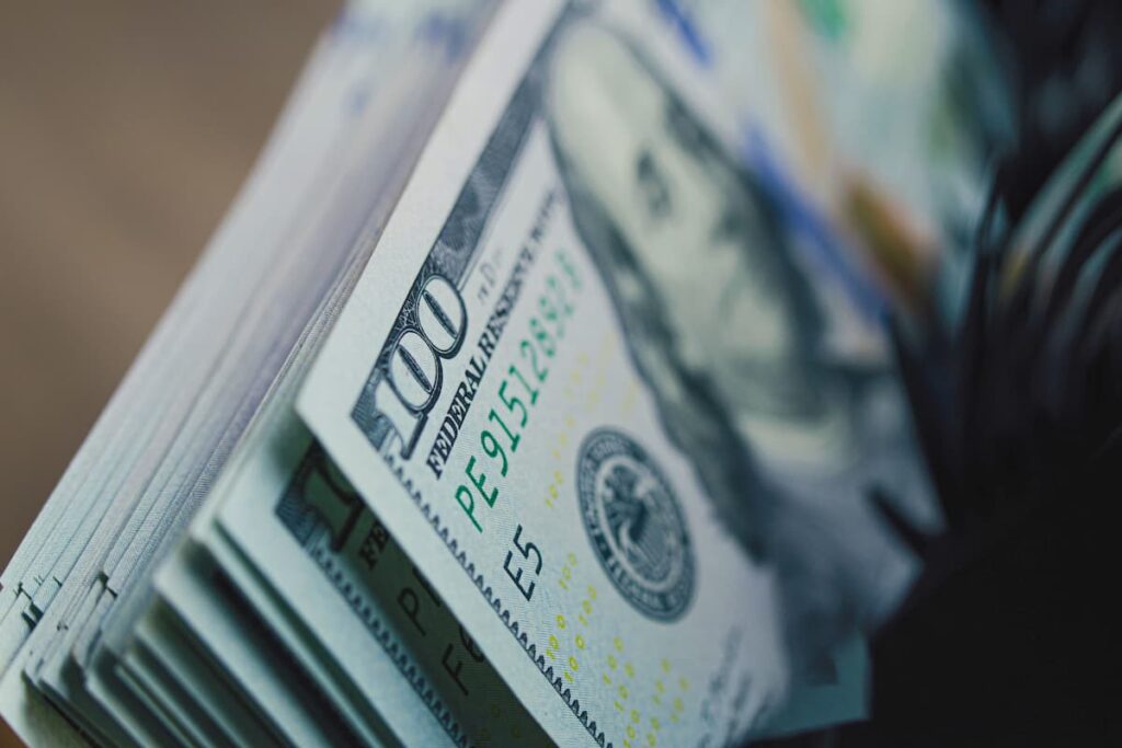 Cash counting machine counts hundred dollar bills.