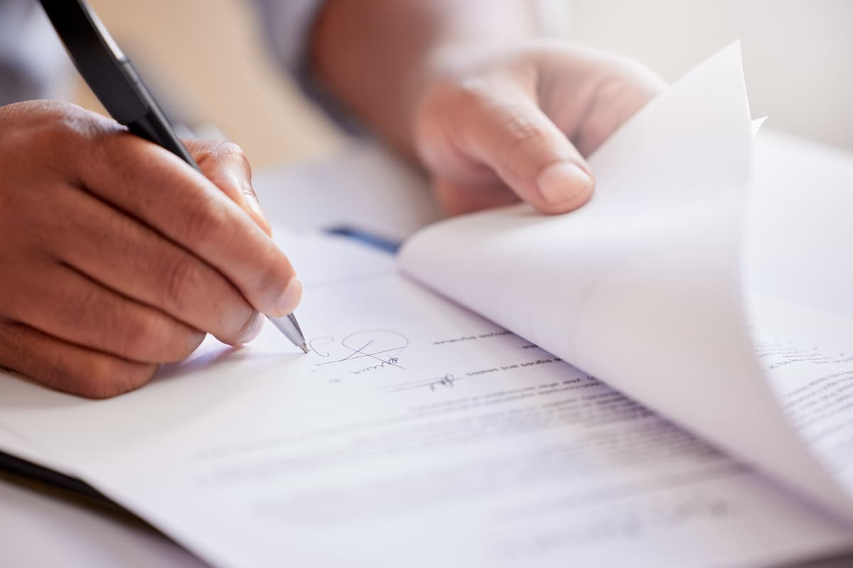 Hands, signature and writing on contract for deal at record company for music license in office.