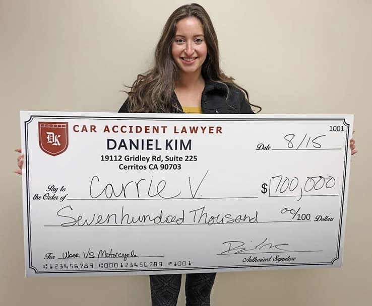 DK Law Client Image with a Jumbo Check of $700,000 for an Uber vs Motorcycle Case