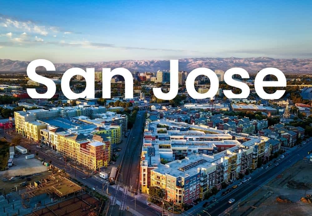 Aerial view of San Jose cityscape with downtown buildings and surrounding mountains, showcasing Silicon Valley’s urban landscape.