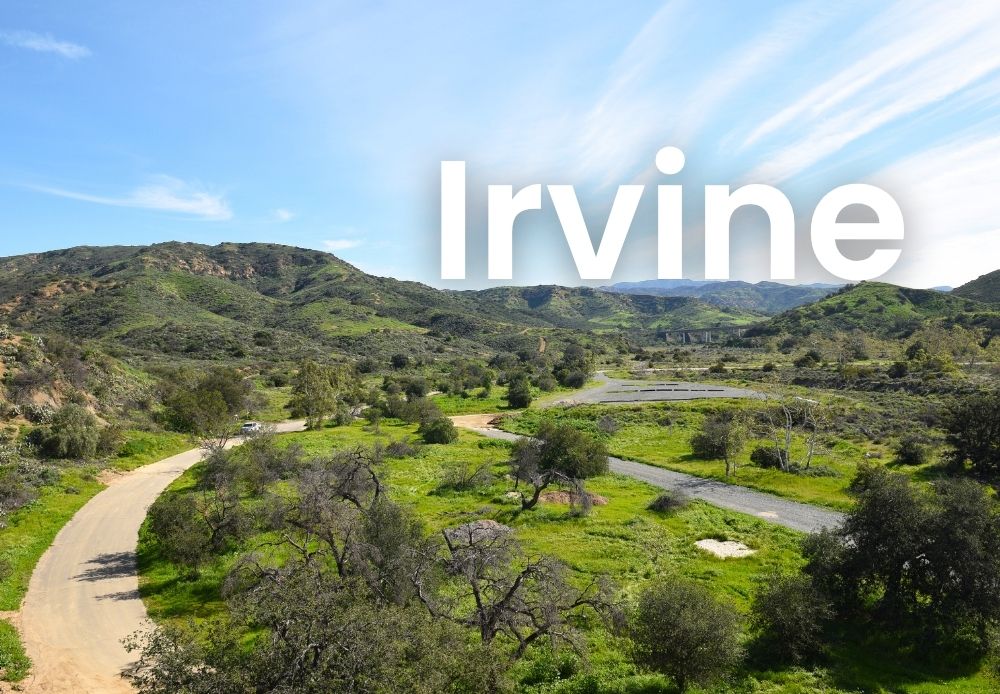 Scenic view of Irvine’s green hills and open trails with large white text reading “Irvine.”