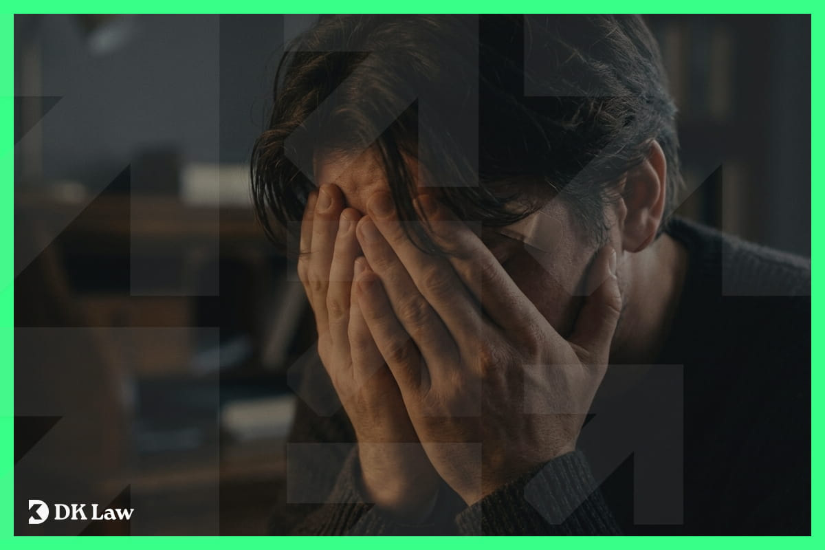 A person sitting with their head in their hands in distress, representing the emotional pain and suffering experienced after a personal injury.