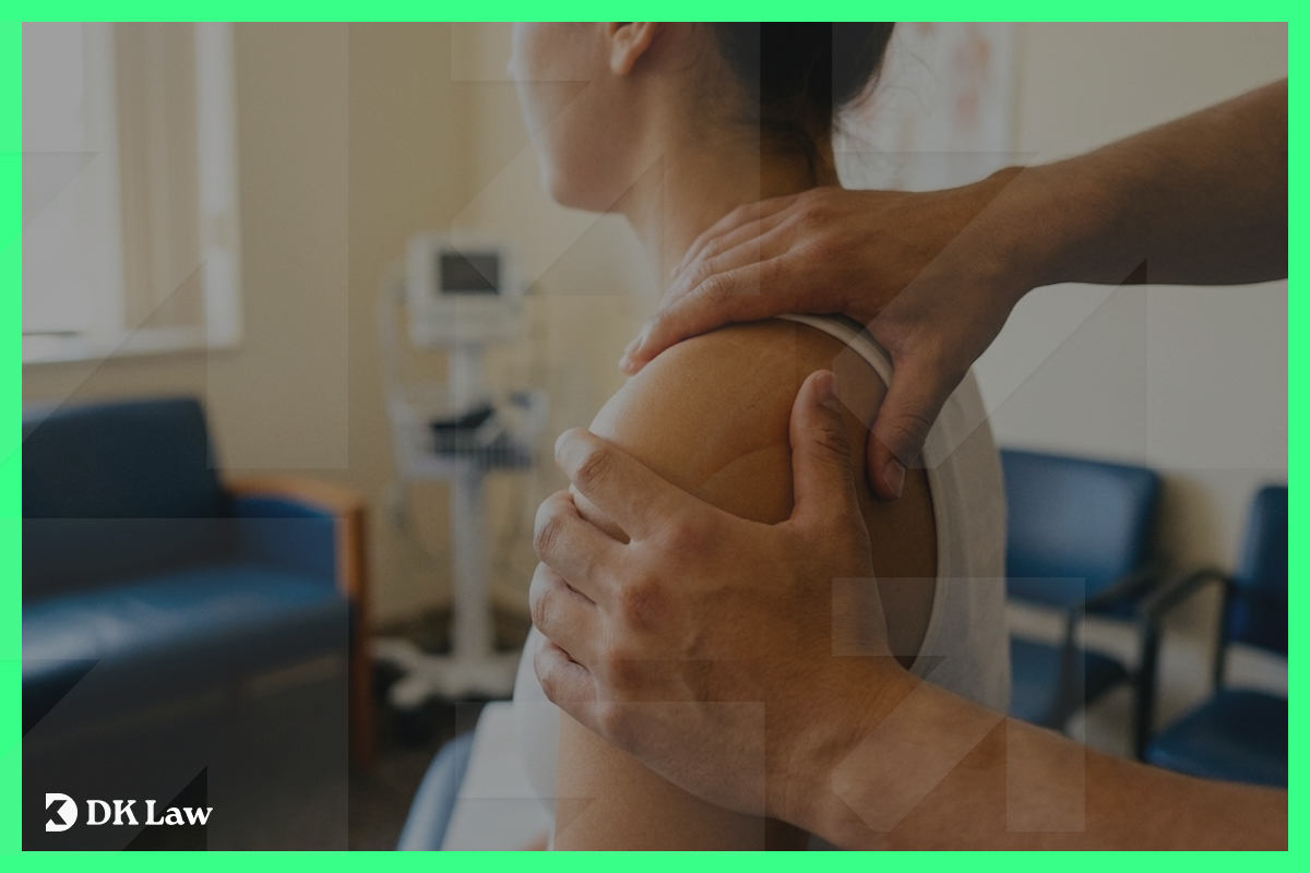 A physical therapist manually treating a patient's shoulder in a clinical setting, representing physical therapy rehabilitation for injuries sustained in a car accident