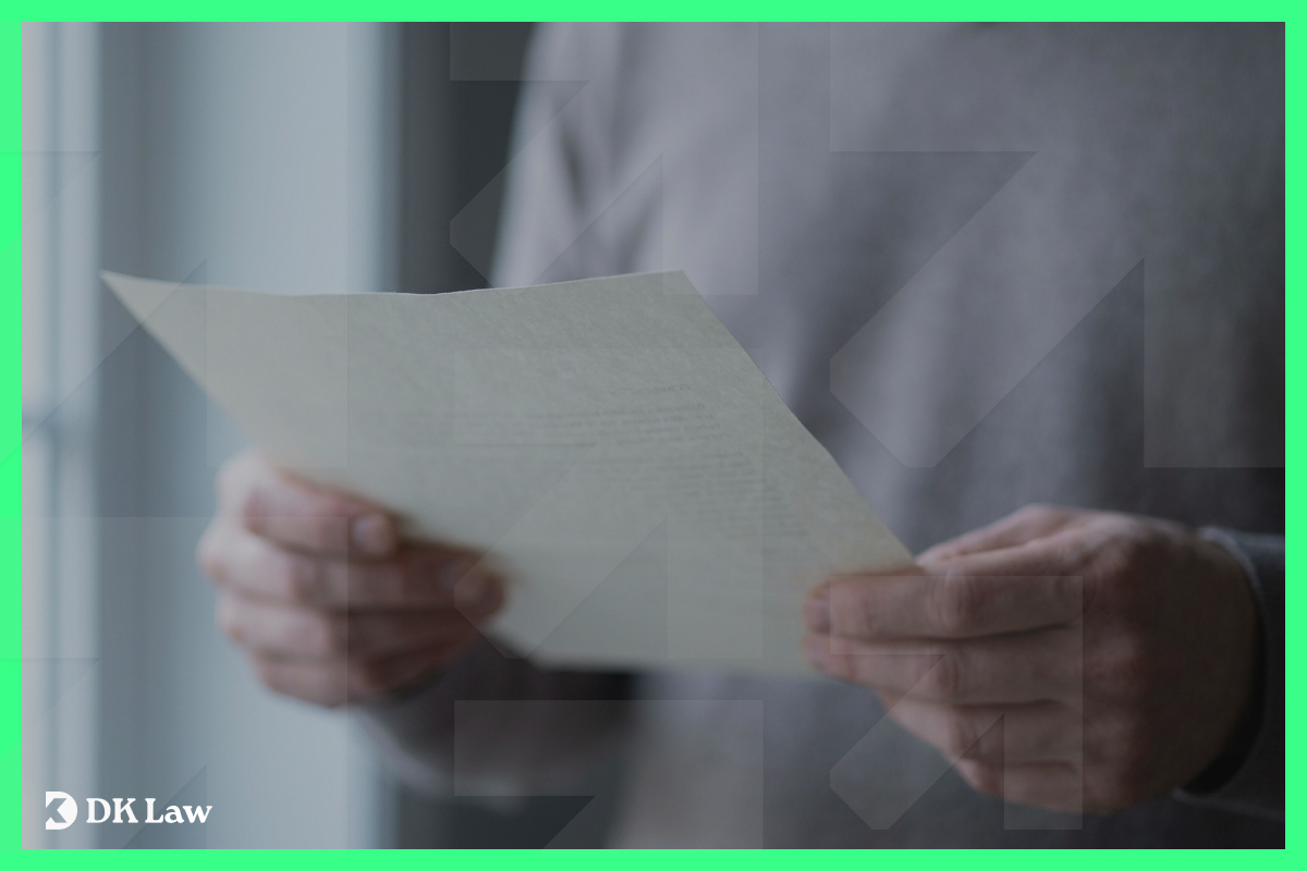 Close-up of hands holding and reviewing a settlement letter