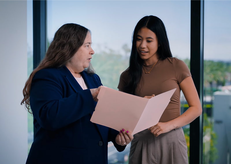 DK Law attorney Caryn Brottman Sanders speaking with a team member.