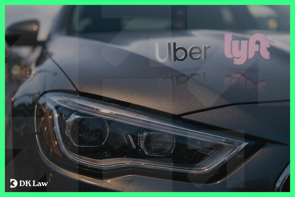 Close-up of a car’s headlight with Uber and Lyft logos on the hood